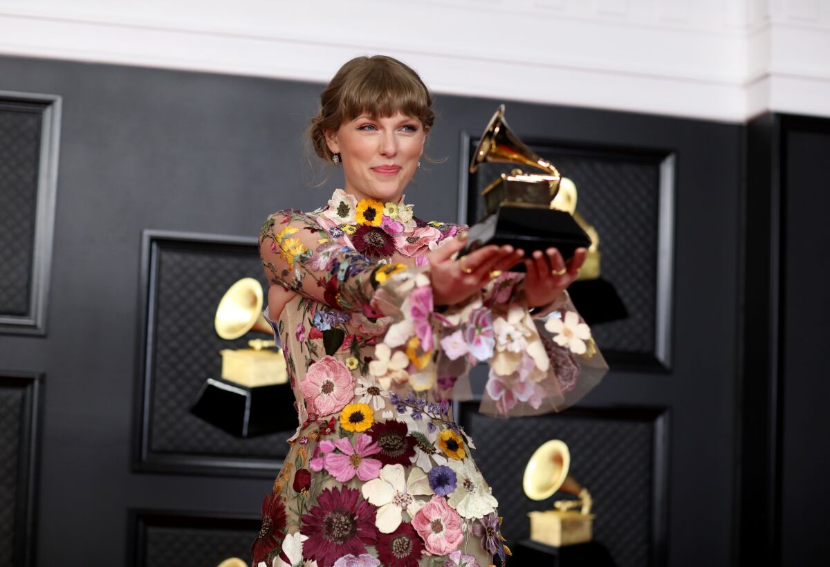 Taylor Swift holds a Grammy trophy