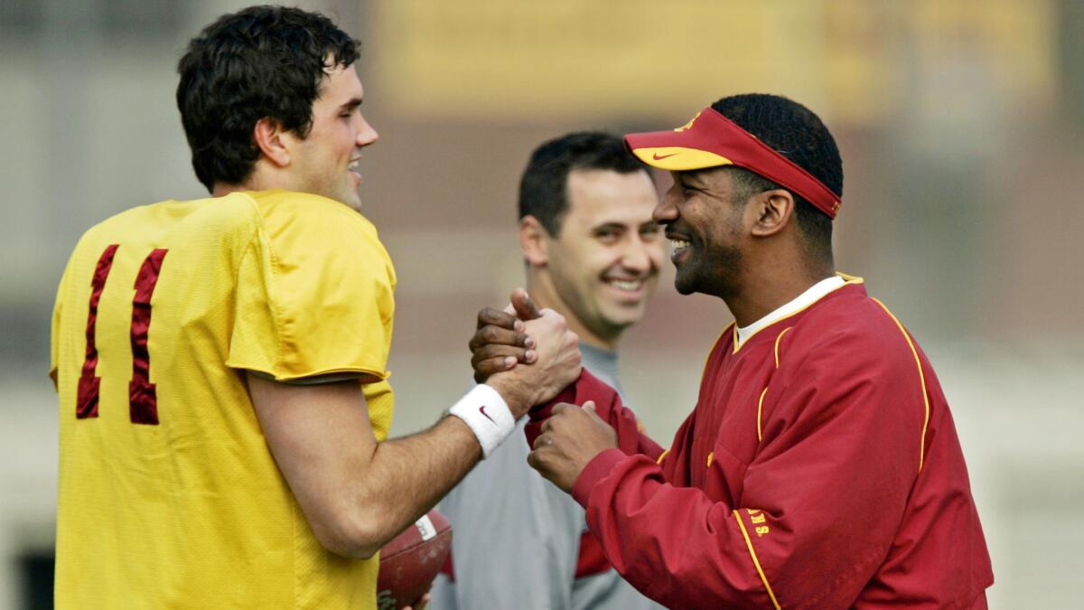 Todd McNair, right, then USC's running backs coach, shares a laugh with quarterback Matt Leinart and then-quarterbacks coach Steve Sarkisian during a team practice in 2005. McNair sued the NCAA after it sanctioned him and USC in connection with the Reggie Bush case.