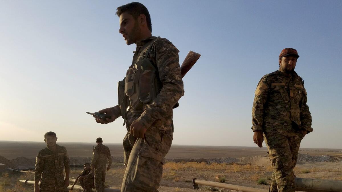 Syrian opposition fighter Raad Abdullah Hamoud at the foot of a desert water tower near mortar craters from what he described as an army attack days earlier.