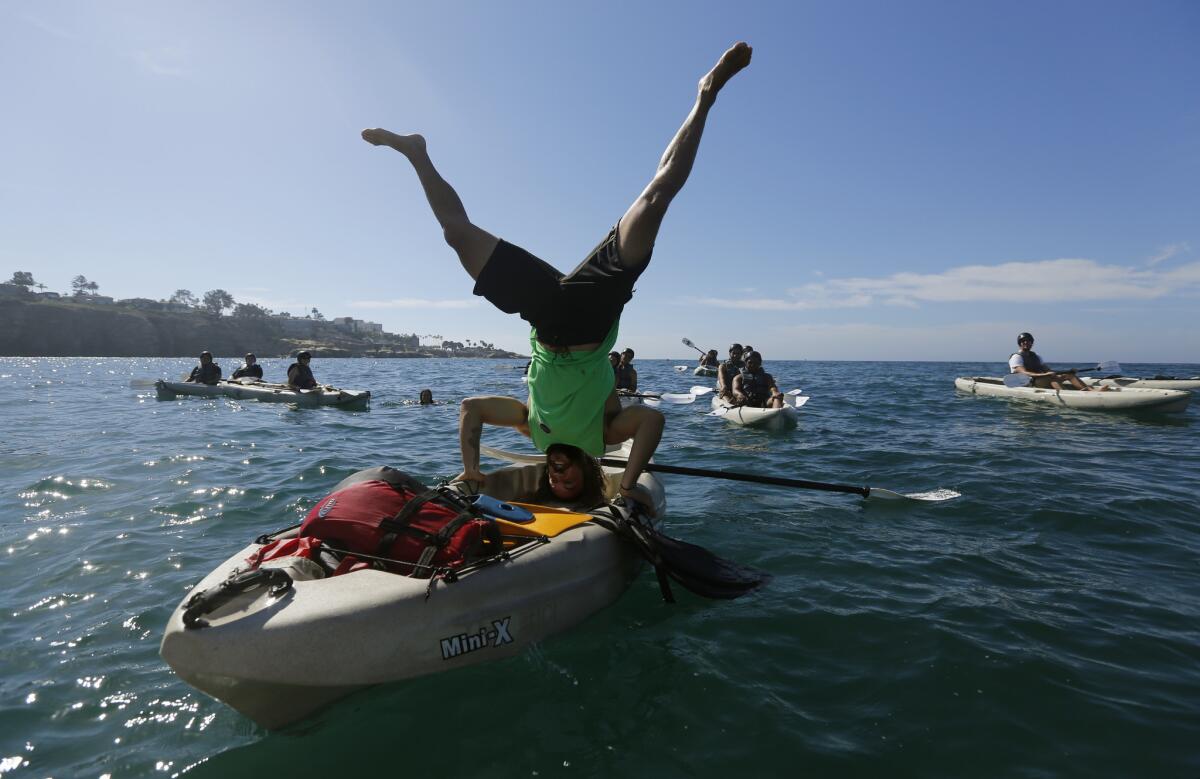 Chris Hodson, a guide with the Everyday California tour company, does a headstand in his kayak in the gentle water.