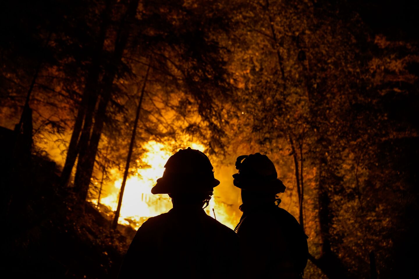 Firefighters keeps watch as the fire line creeps up on Highway 9 during the CZU Lightning complex fire.