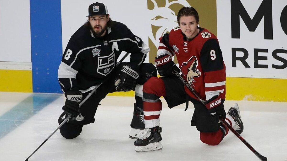 Kings defenseman Drew Doughty, left, kneels next to Arizona Coyotes forward Clayton Keller before the start of the NHL All-Star skills competition on Friday.