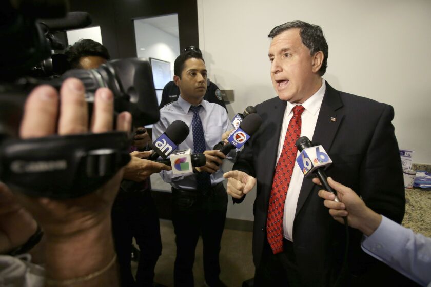 FILE - Former Doral, Fla., City Manager Joe Carollo, gestures as he talks to members of the media after being fired by the City Council on April 28, 2014 in Doral. A federal jury in South Florida awarded $63.5 million on Thursday, June 1, 2023, to a pair of businessmen who claimed Miami City Commissioner Carollo used his office to harass them after they supported the commissioner's political opponent. (AP Photo, File)