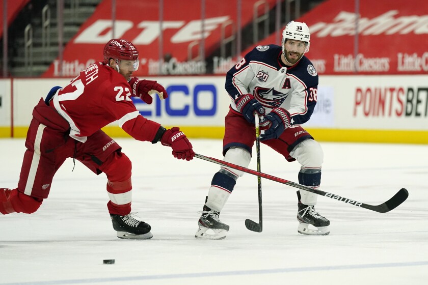Columbus Blue Jackets center Boone Jenner (38) passes next to Detroit Red Wings defenseman Patrik Nemeth (22) during the third period of an NHL hockey game, Sunday, March 28, 2021, in Detroit. (AP Photo/Carlos Osorio)