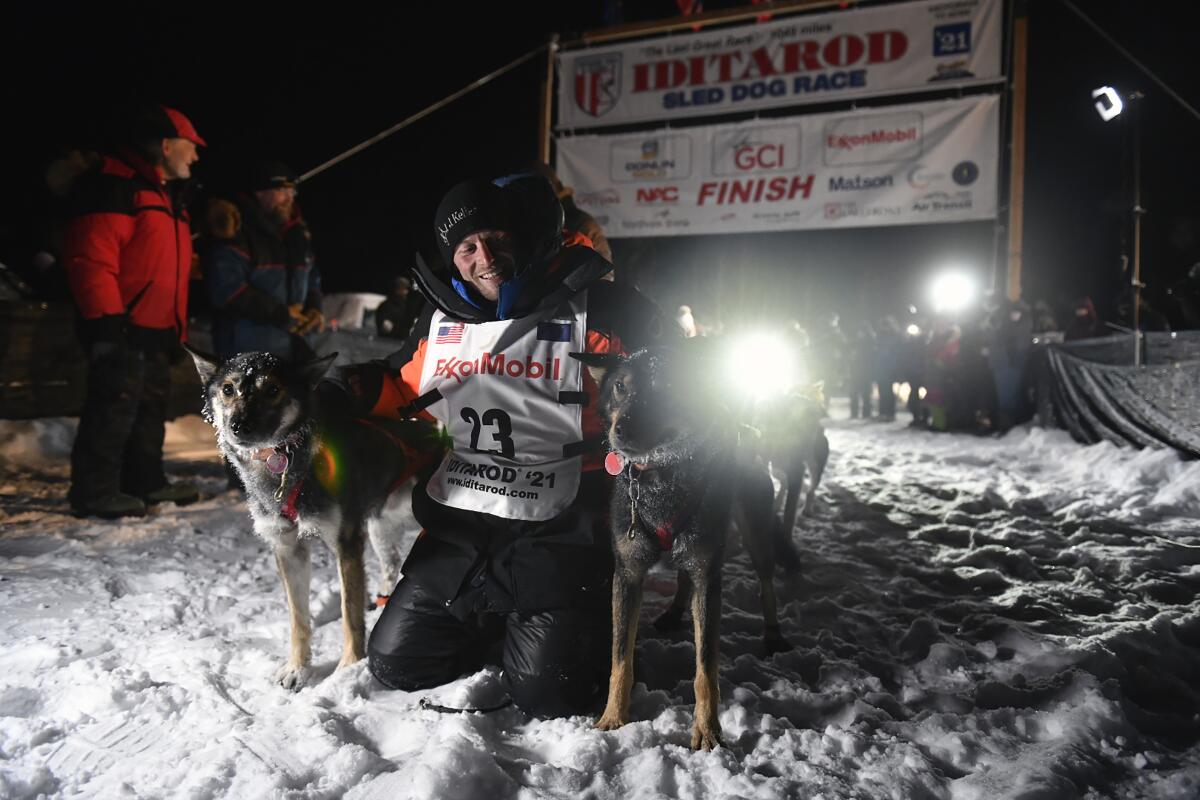 Dallas Seavey kneels alongside his dogs.