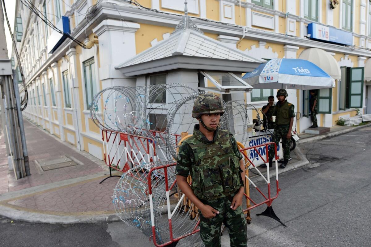 Thai soldiers stand guard Thursday at a roadblock outside the Defense Ministry building.