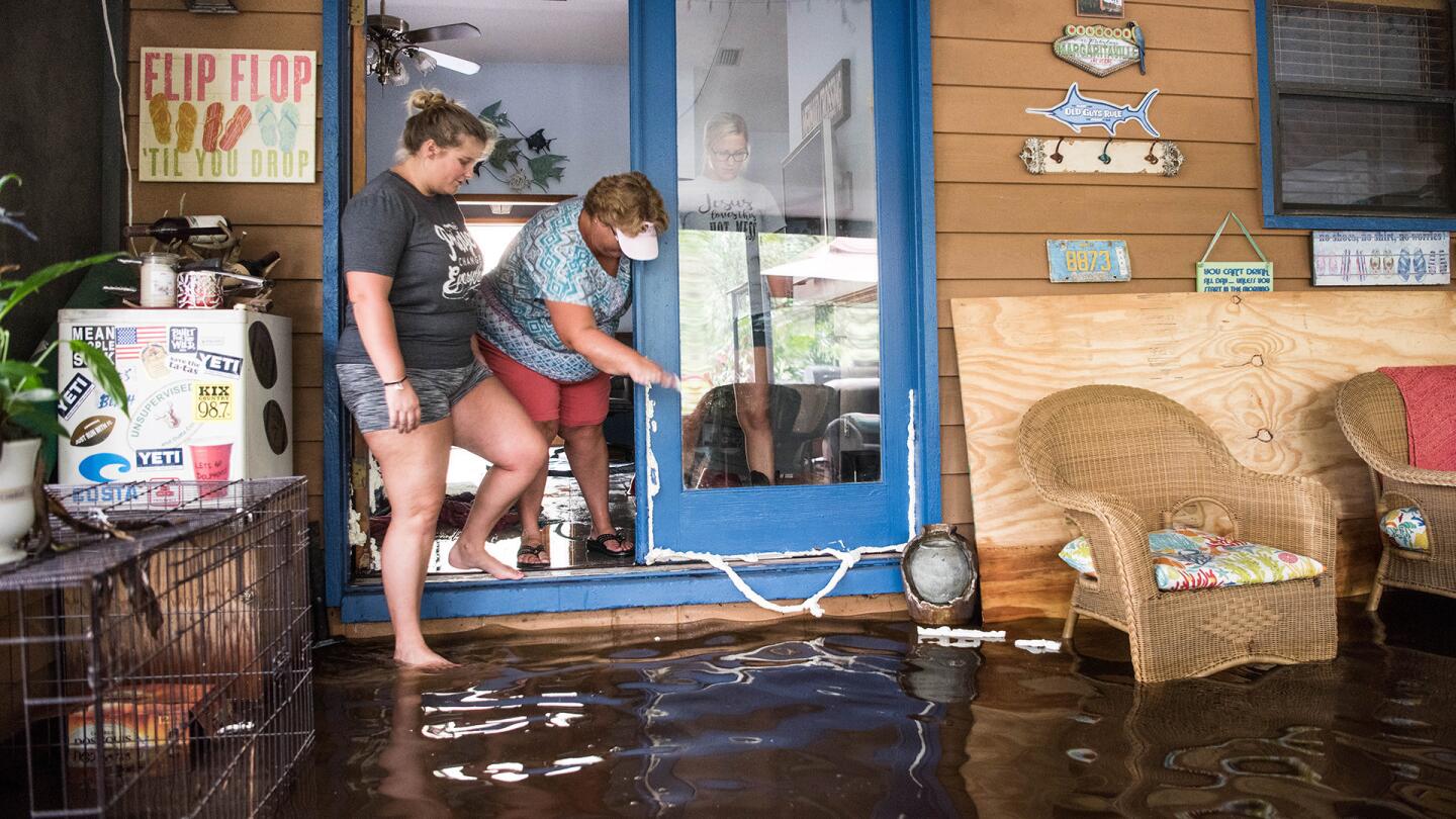 Holly Lands, left, Mindy Lands, and Morgan Lindsey walk down their street inundated by flood waters caused by Hurricane Irma September 12, 2017 near Palatka, Florida.