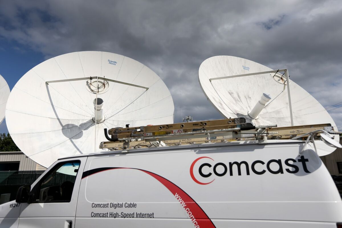 A Comcast truck is parked at one of the company'sr centers in Pompano Beach, Fla. Comcast is the nation's largest cable company, with more than 22 million subscribers and $64 billion a year in revenue.