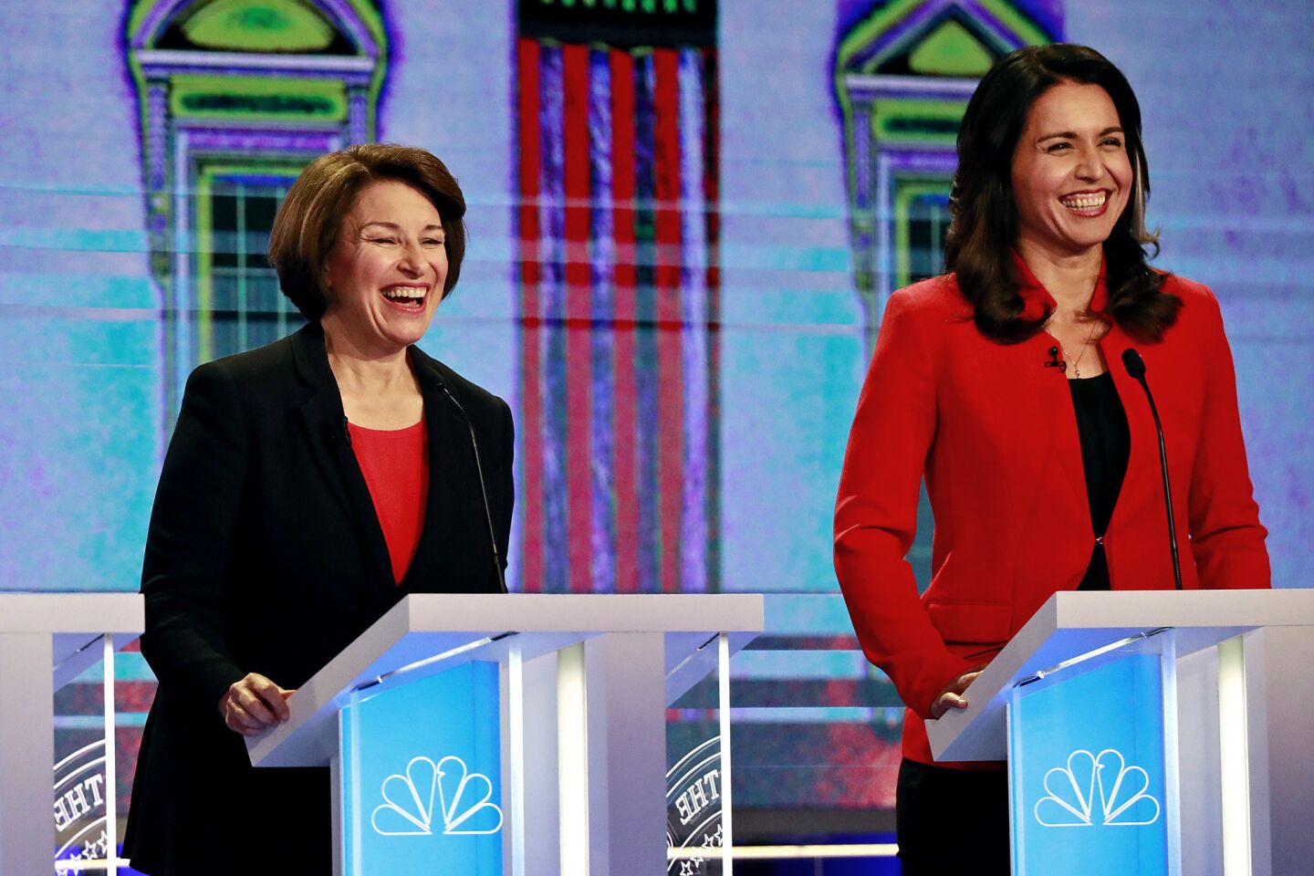 Democratic presidential candidates Sen. Amy Klobuchar, D-Minn., and Rep. Tulsi Gabbard, D-Hawaii, smile during a Democratic primary debate hosted by NBC News at the Adrienne Arsht Center for the Performing Arts, Wednesday, June 26, 2019, in Miami.