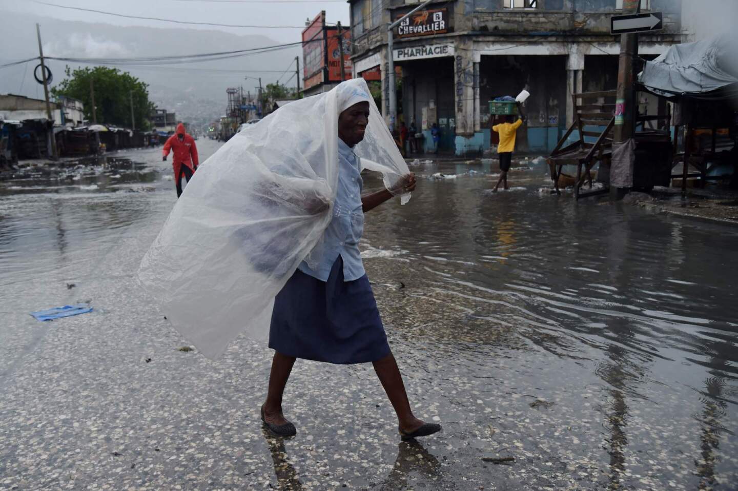 A woman protects herself from the rain in Port-au-Prince as Hurricane Matthew makes landfall in southwestern Haiti early Tuesday.
