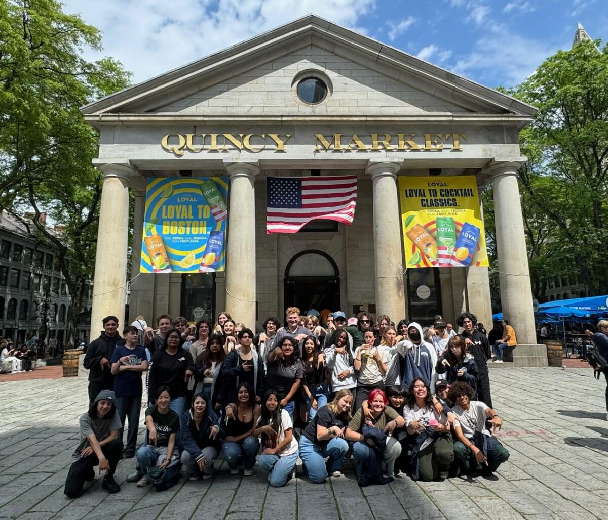 Members of the Newport Harbor wind ensemble and orchestra pose for a group picture at Quincy Market.