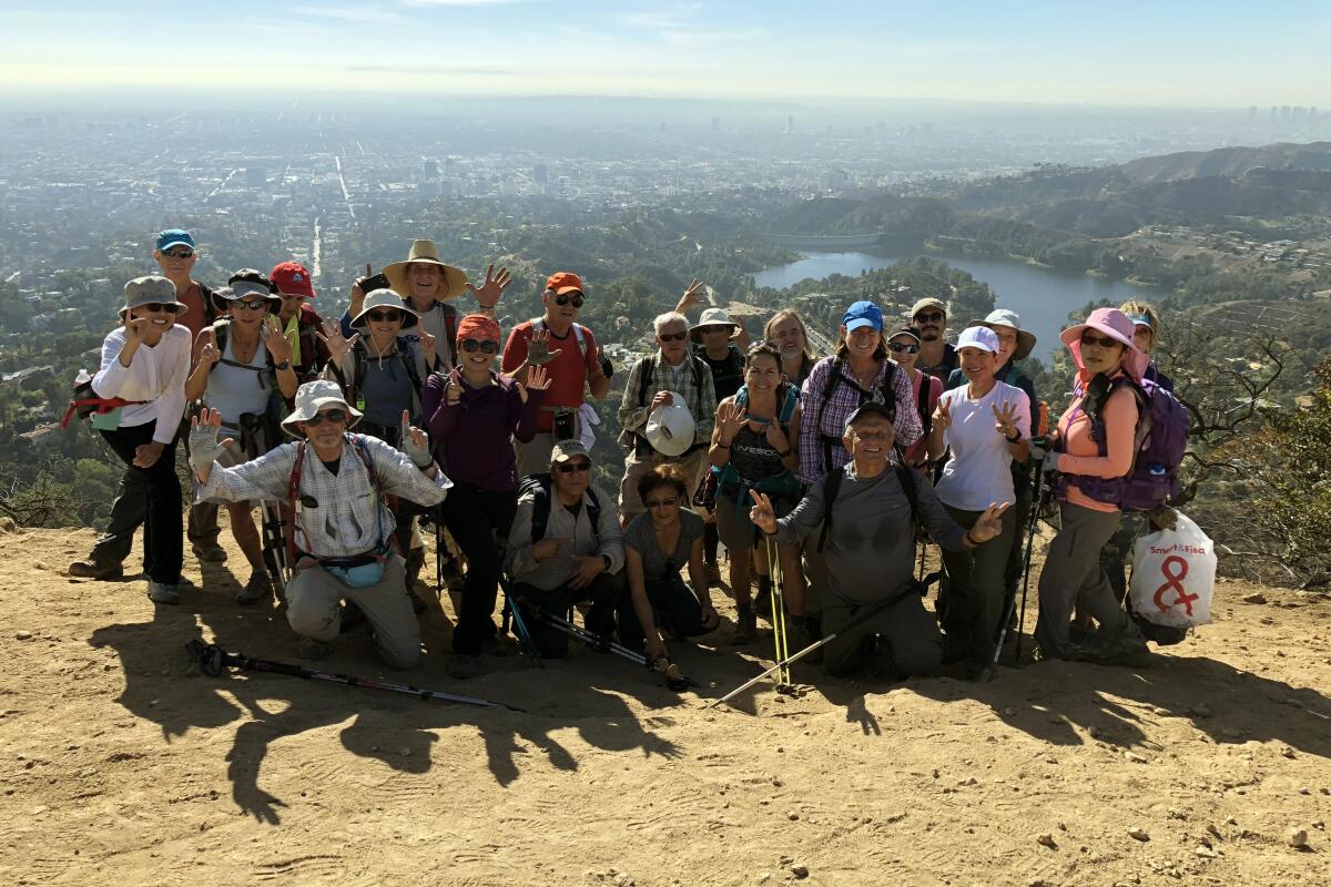 Sierra Club takes hikers to trails near and far. Here a group poses atop Mt. Lee in Griffith Park where the Hollywood sign is located.