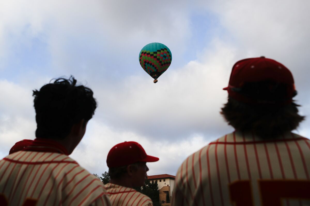 Cathedral players pause to watch a hot air balloon traverse overhead during their game against St. Augustine.