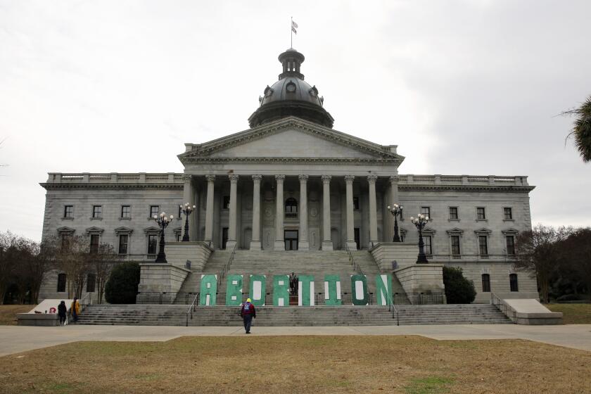 A group who opposes a bill that would ban almost all abortions in South Carolina put up a sign outside the Statehouse on Tuesday, Feb. 2, 2021, in Columbia, S.C. The bill has passed the Senate and been sent to the House. (AP Photo/Jeffrey Collins)