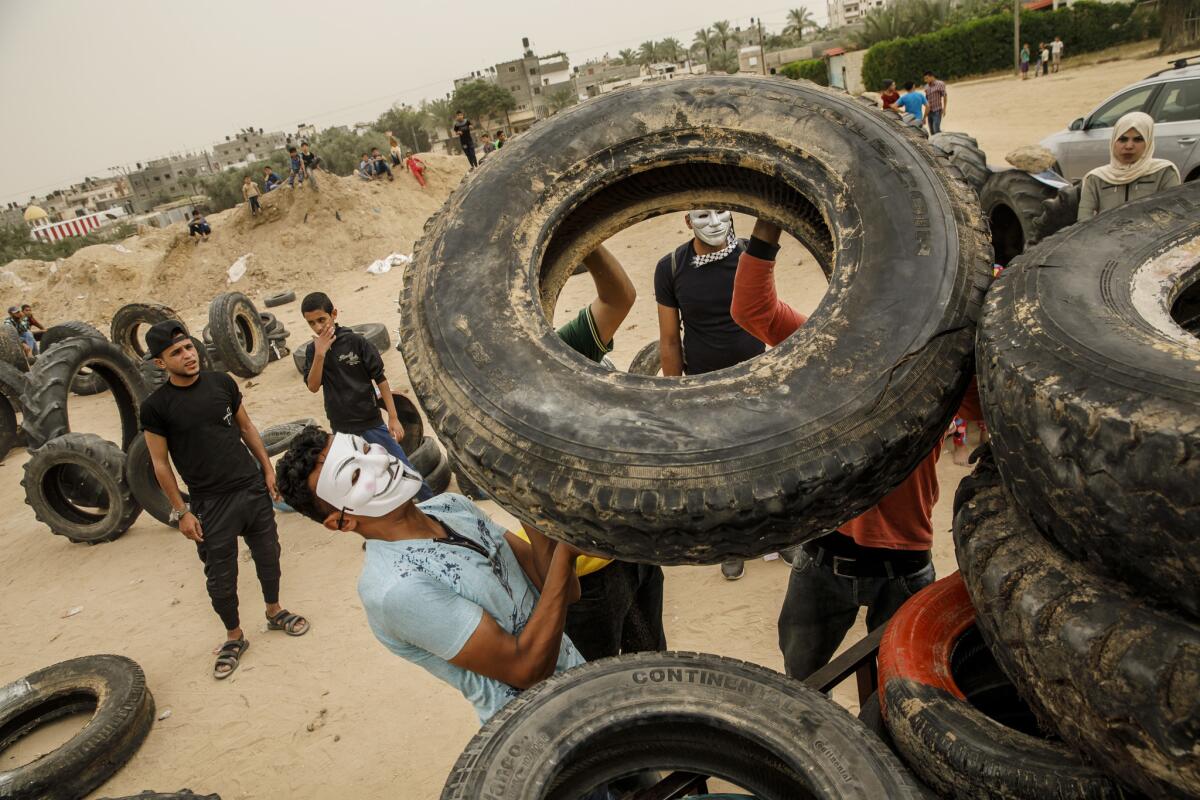 Youths near Khan Yunis in the Gaza Strip last week organize tires to be used in demonstrations. The tires are often set on fire to create a smokescreen.