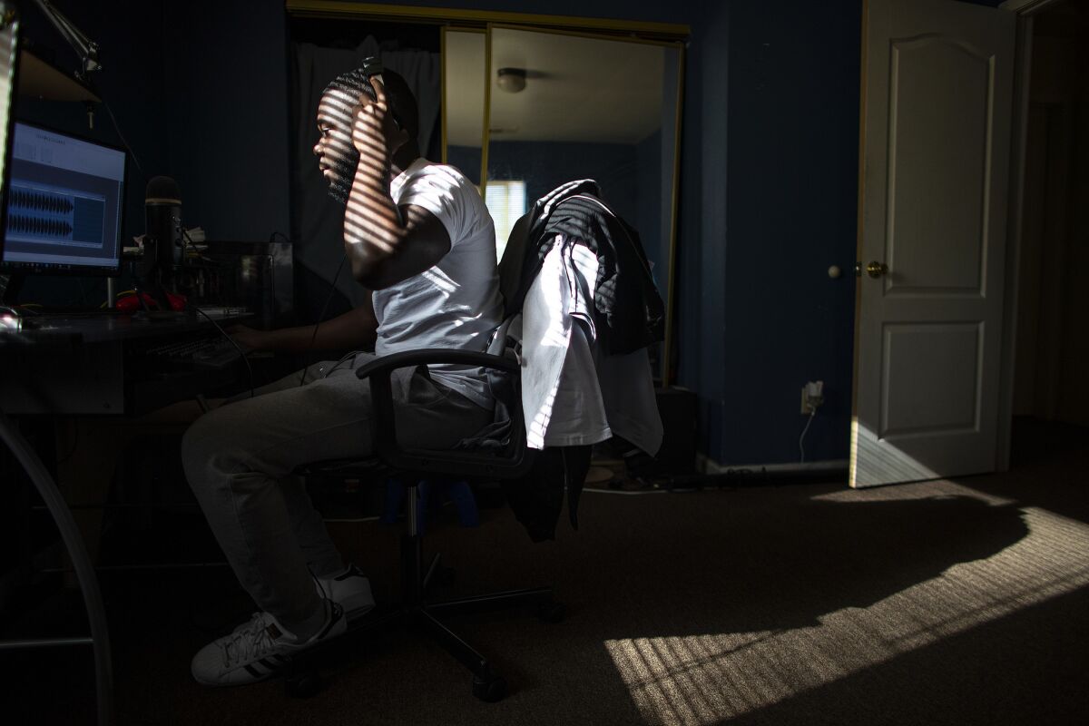 Damion Lester Jr. works on a musical score on a computer he built in his bedroom at home, where he lives with his grandparents, in Los Angeles.