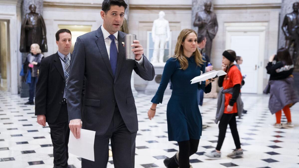 House Speaker Paul D. Ryan (R-Wis.) heads to the House chamber Thursday before a vote on the $1.3-trillion spending bill.