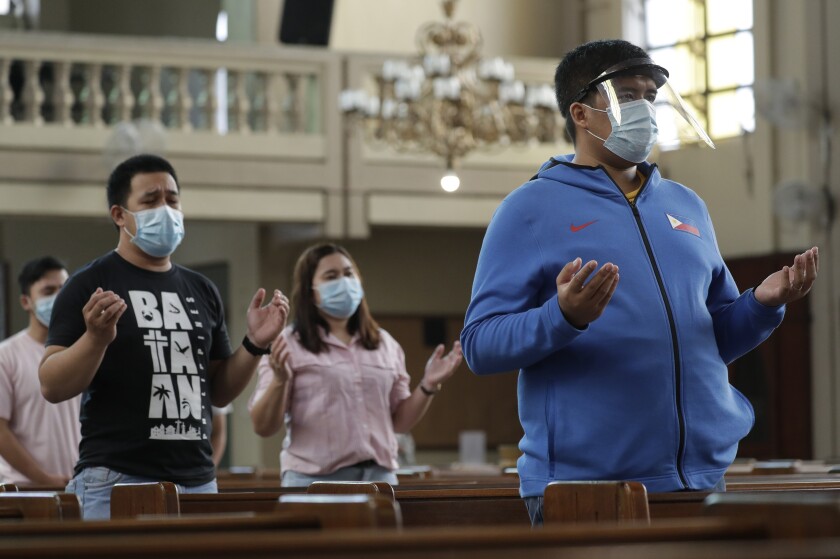 Parishioners wearing masks as a measure to prevent the spread of COVID19 pray during a Mass at the Our Lady of Consolation Parish on Sunday, Aug. 2, 2020, in Quezon city, Philippines. Coronavirus infections in the Philippines continues to surge Sunday as medical groups declared the country was waging "a losing battle" against the contagion and asked the president to reimpose a lockdown in the capital. (AP Photo/Aaron Favila)