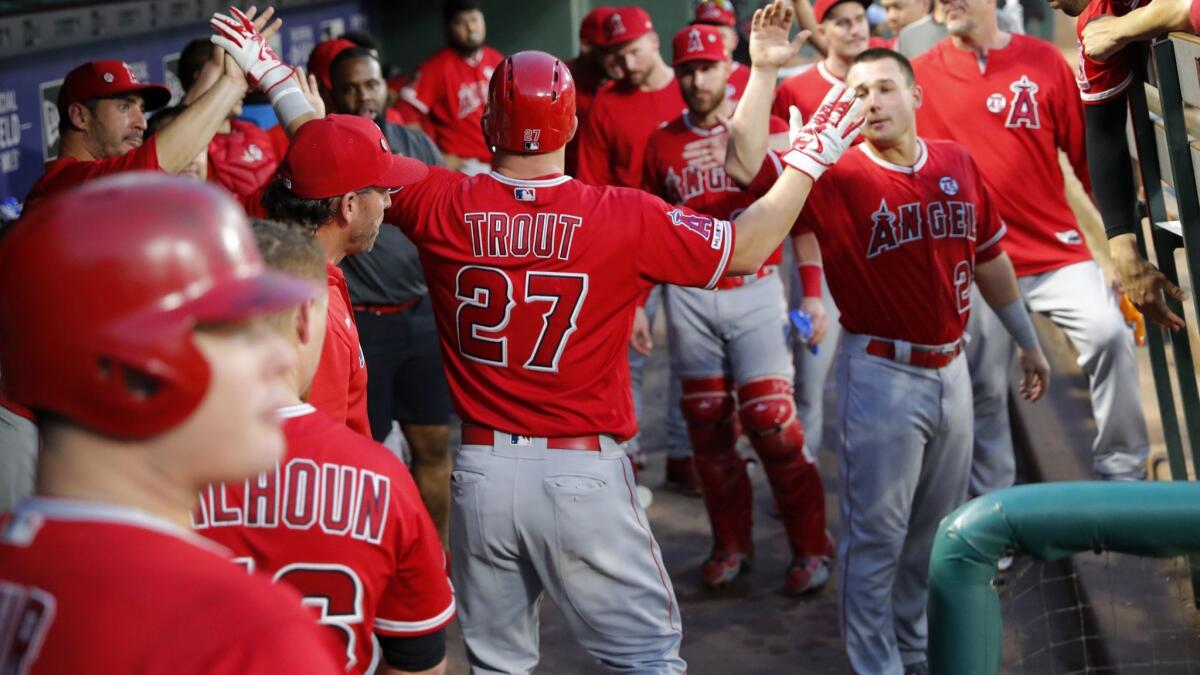 Angels' Mike Trout (27) is congratulated in the dugout after hitting a solo home run against the Texas Rangers in the sixth inning in Arlington, Texas on Wednesday.