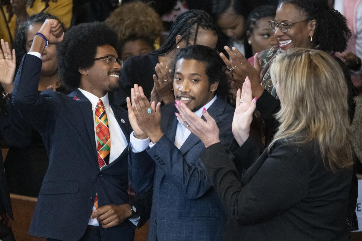Expelled Reps. Justin Pearson, left, and Rep. Justin Jones smile and wave to a cheering audience  at Fisk University 