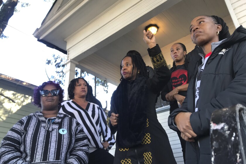 FILE - In this Dec. 30, 2019, file photo, Sharena Thomas, left, Carroll Fife, center, Dominique Walker, second from right, and Tolani KIng, right, stand outside a vacant home they took over on Magnolia Street in West Oakland, Calif. Homeless women ordered by a judge last week to leave a vacant house they occupied illegally in Oakland for two months have been evicted by sheriff's deputies. They removed two women and a male supporter Tuesday, Jan. 14, 2020, from the home before dawn in a case highlighting California's severe housing shortage and growing homeless population. (Kate Wolffe/KQED via AP, File)