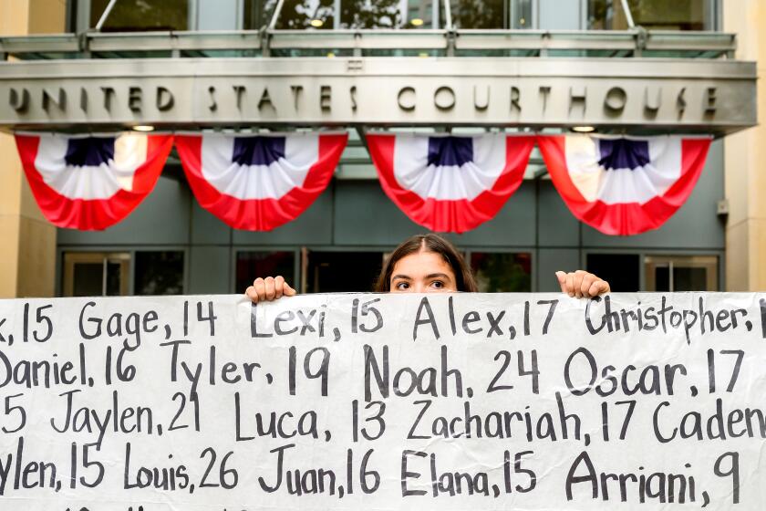 Olivia Konar holds a banner with names of young people who advocates say died as a result of social media outside the Ronald V. Dellums Federal Building and U.S. Courthouse on Tuesday, Aug. 18, 2026, in Oakland, Calif. Her sister Coco Konar died in 2022 when she was 17. (AP Photo/Noah Berger)