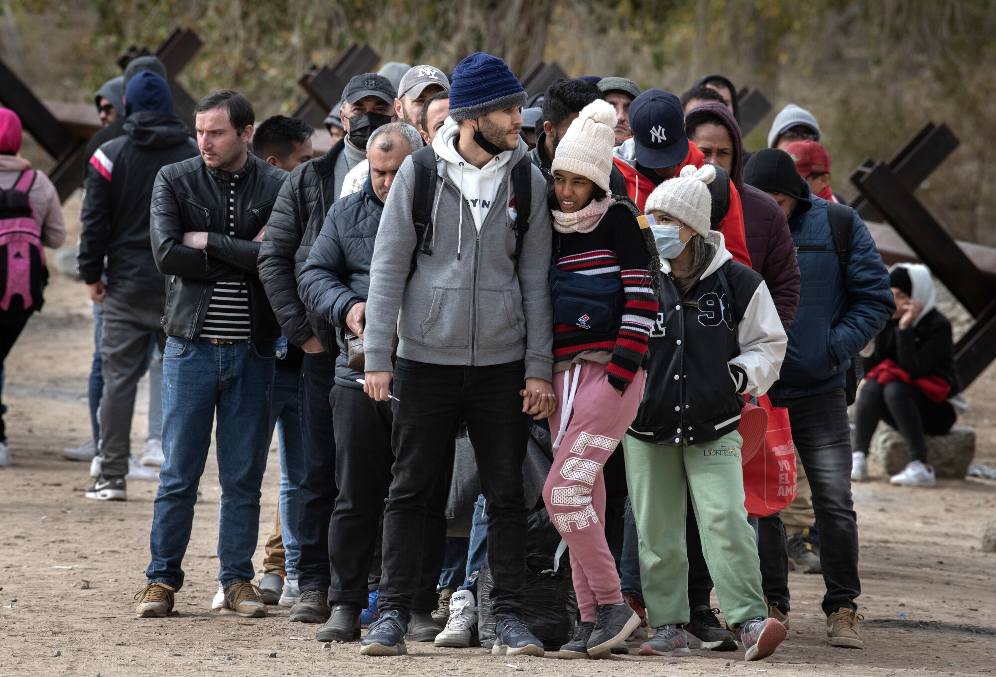 A group of migrants wait on the Colorado River levee in San Luis, Arizona. 