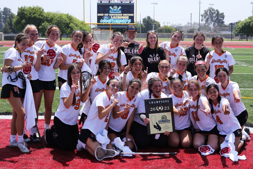 Huntington Beach High School girls' lacrosse team and coaches pose for pictures with the 2023 CIF Championship Division 3 plaque after winning the CIF Southern Section Division 3 title against Portola High School girls' lacrosse team at the Allen Layne Stadium at Downey High School in Downey on Saturday, May 13, 2023. (Photo by James Carbone)