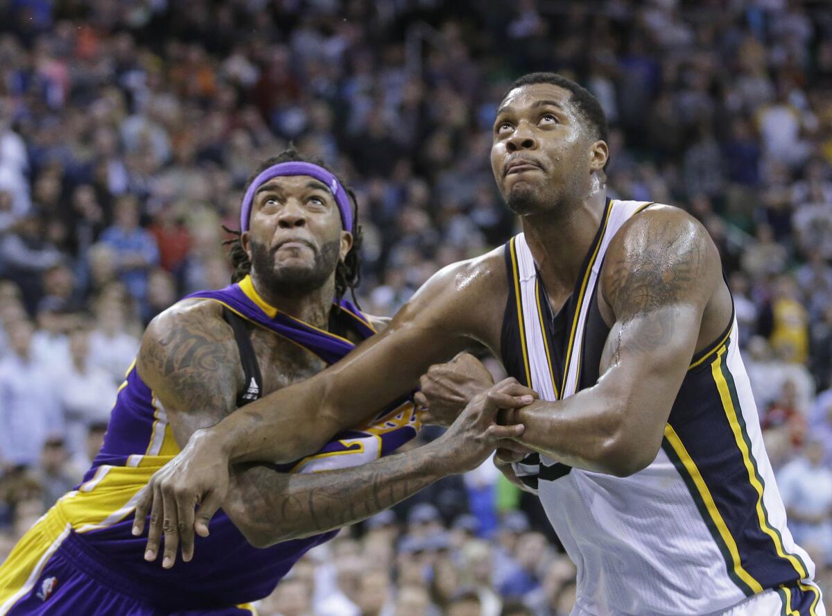 Jordan Hill and Utah forward Derrick Favors battle for position during the fourth quarter of the Lakers' 100-97 win over Utah.