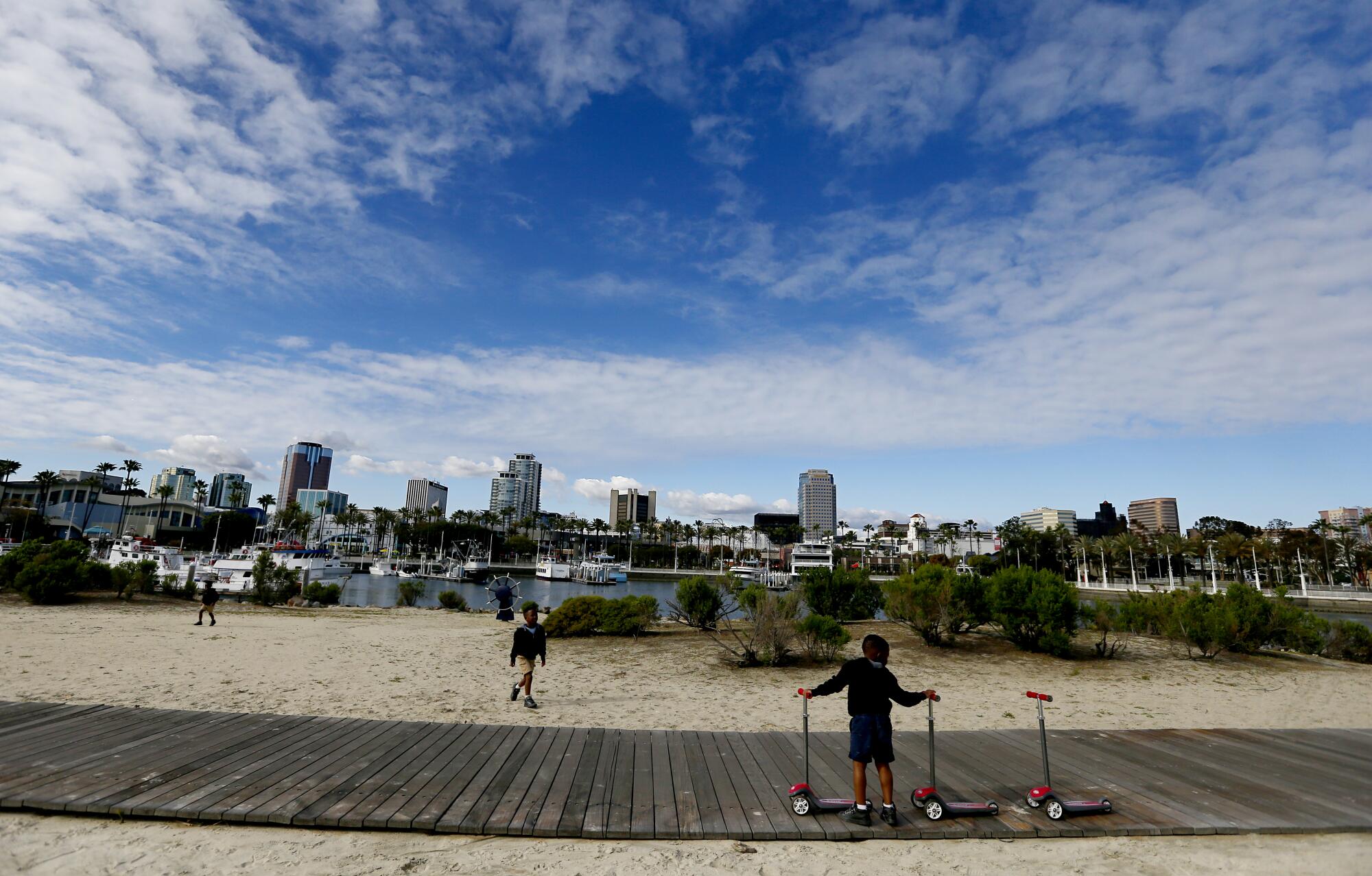 Children play on a deserted beach in downtown Long Beach