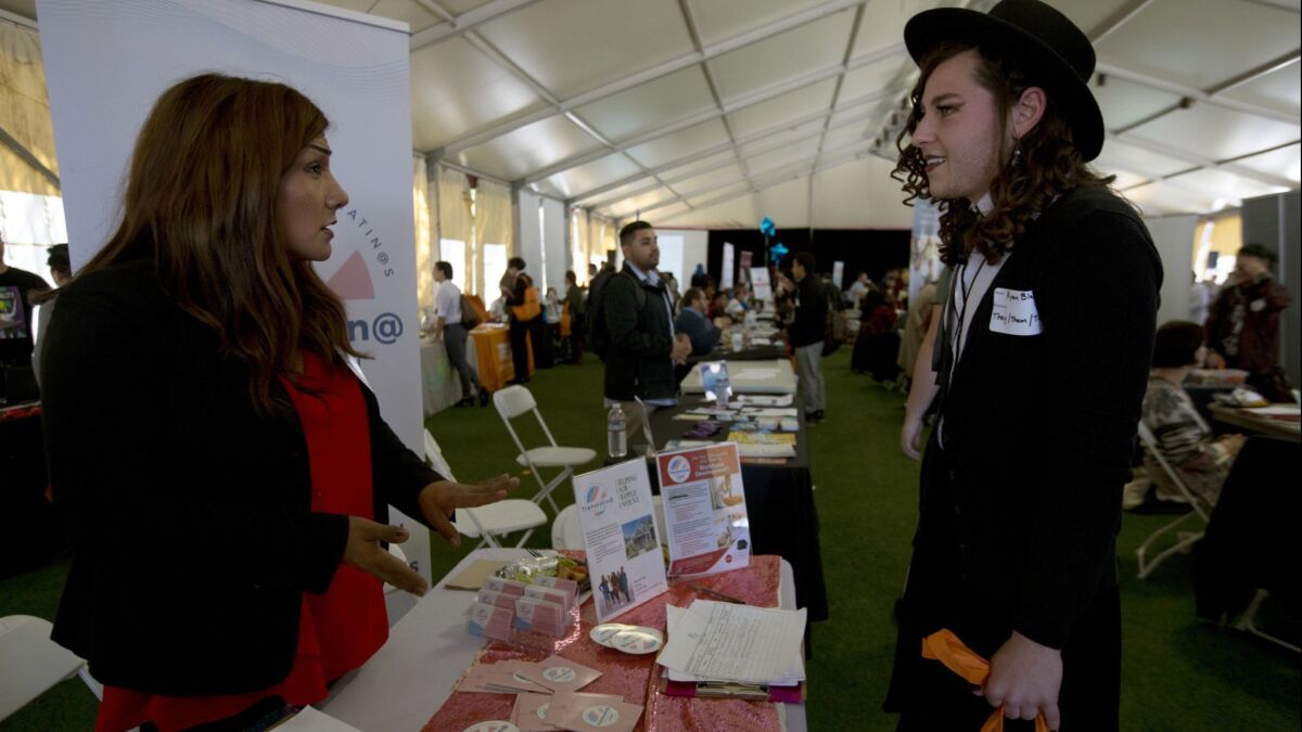 Ryan Blake, 22, right, speaks with an employer representative at the St. John's Well Child and Family Center job fair for the transgender community at Los Angeles Trade-Tech College on March 13.