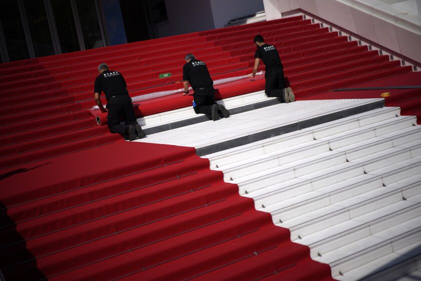 Crew members install the red carpet at the Palais des Festivals