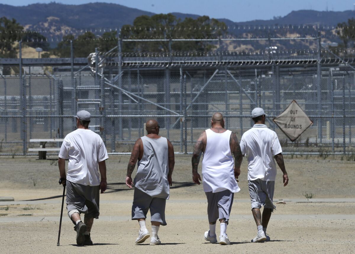 Inmates walk the exercise yard at a prison