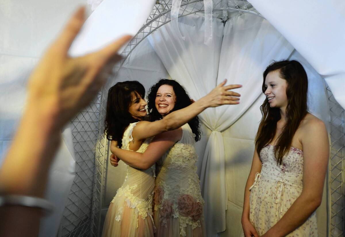 Andrea Taylor, left, hugs partner Sallee Taylor and reaches for Taylor's daughter, Grace Meier, 15, after the couple were married Monday in West Hollywood. For gay couples in states that don't recognize their marriages, however, a Supreme Court ruling leaves uncertainty about tax laws and other federal rules.