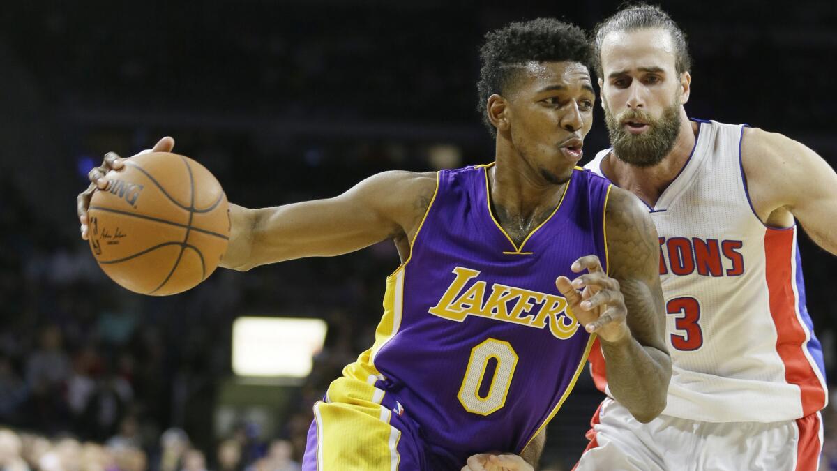 Lakers forward Nick Young, front, drives past Detroit Pistons forward Luigi Datome during the second half of the Lakers' 106-96 win Tuesday.