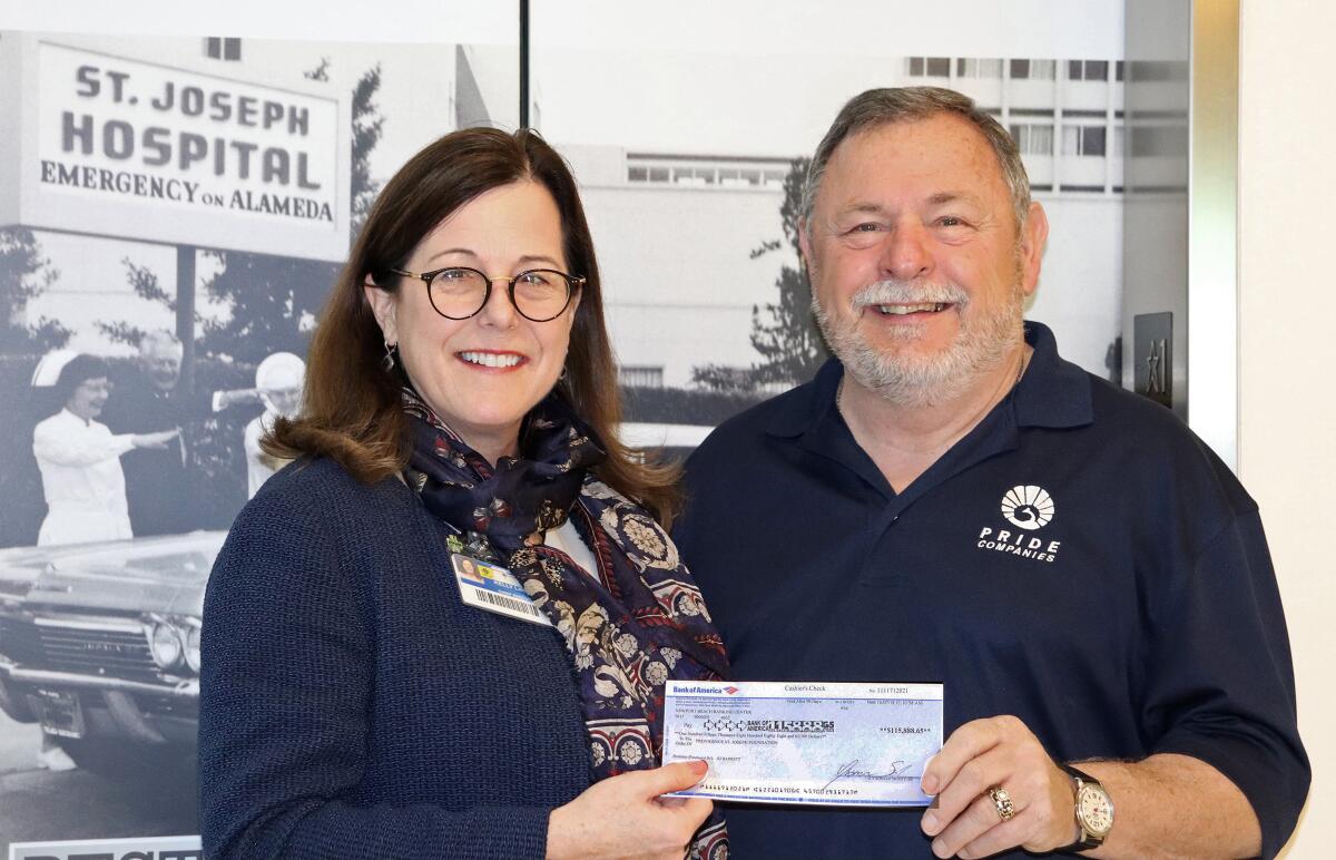Providence St. Joseph Medical Center Chief Executive Kelly Linden accepts a check in the memory of the late John Baldaseroni from his brother Don Baldaseroni.