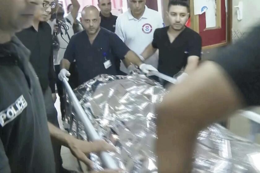 This image taken from an Associated Press video shows Aysenur Ezgi Eygi's body being transported through the Rafidia Surgical Hospital, where she was taken after she was fatally shot by Israeli soldiers, Sept. 6, 2024, in the West Bank city of Nablus. (AP Photo/Aref Tufaha)