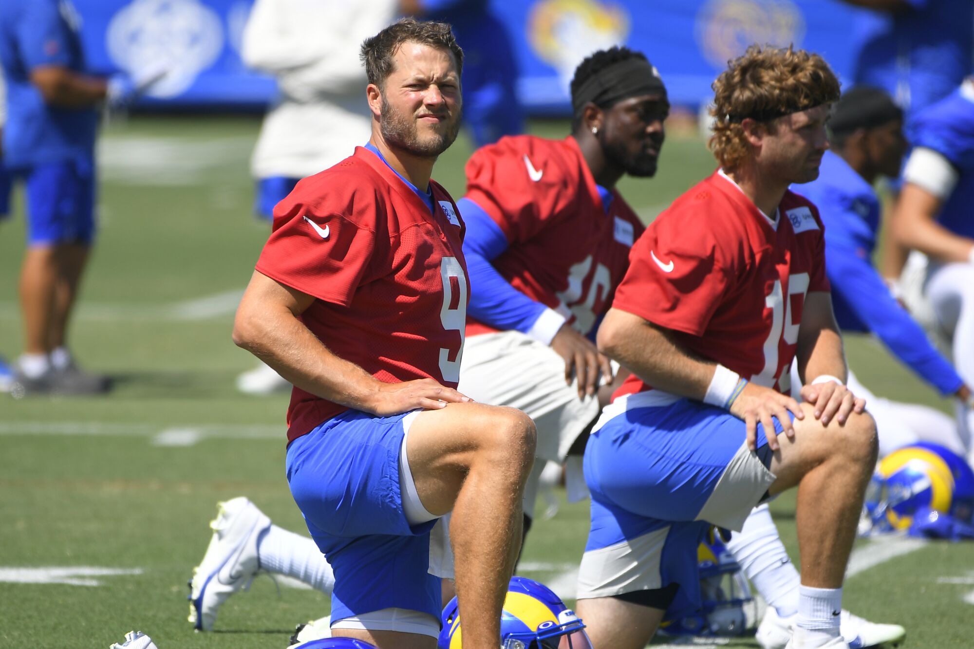 Rams quarterback Matthew Stafford stretches next to Bryce Perkins and Devlin Hodges during training camp.