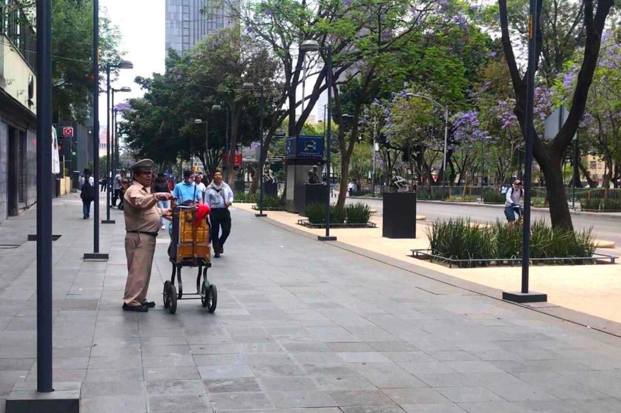 Un organillero acompaña con su música a las pocas personas que caminan frente a la turística Alameda Central, en Ciudad de México.