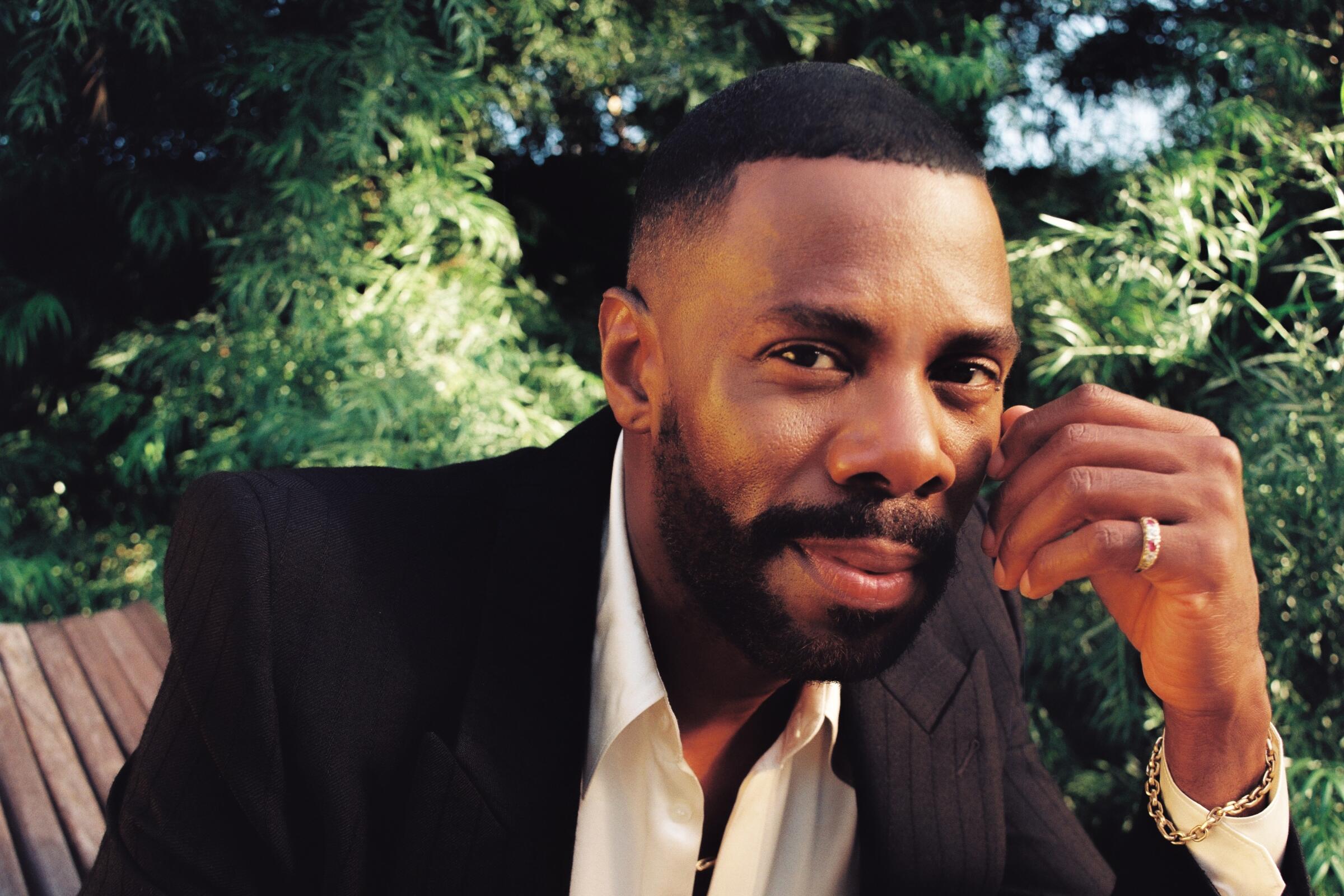 Colman Domingo wears a sport coat and button-up shirt for a portrait outside.