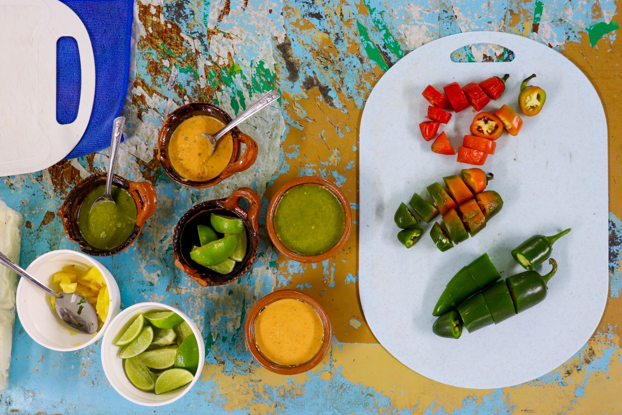 A platter of peppers, and bowls of side sauces, limes and other dishes.