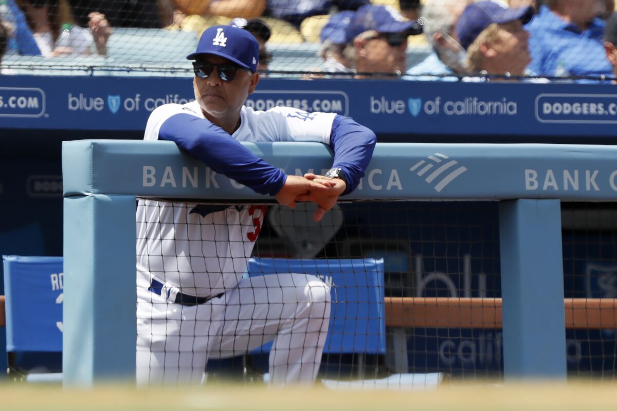 Dodgers manager Dave Roberts looks over from the dugout.