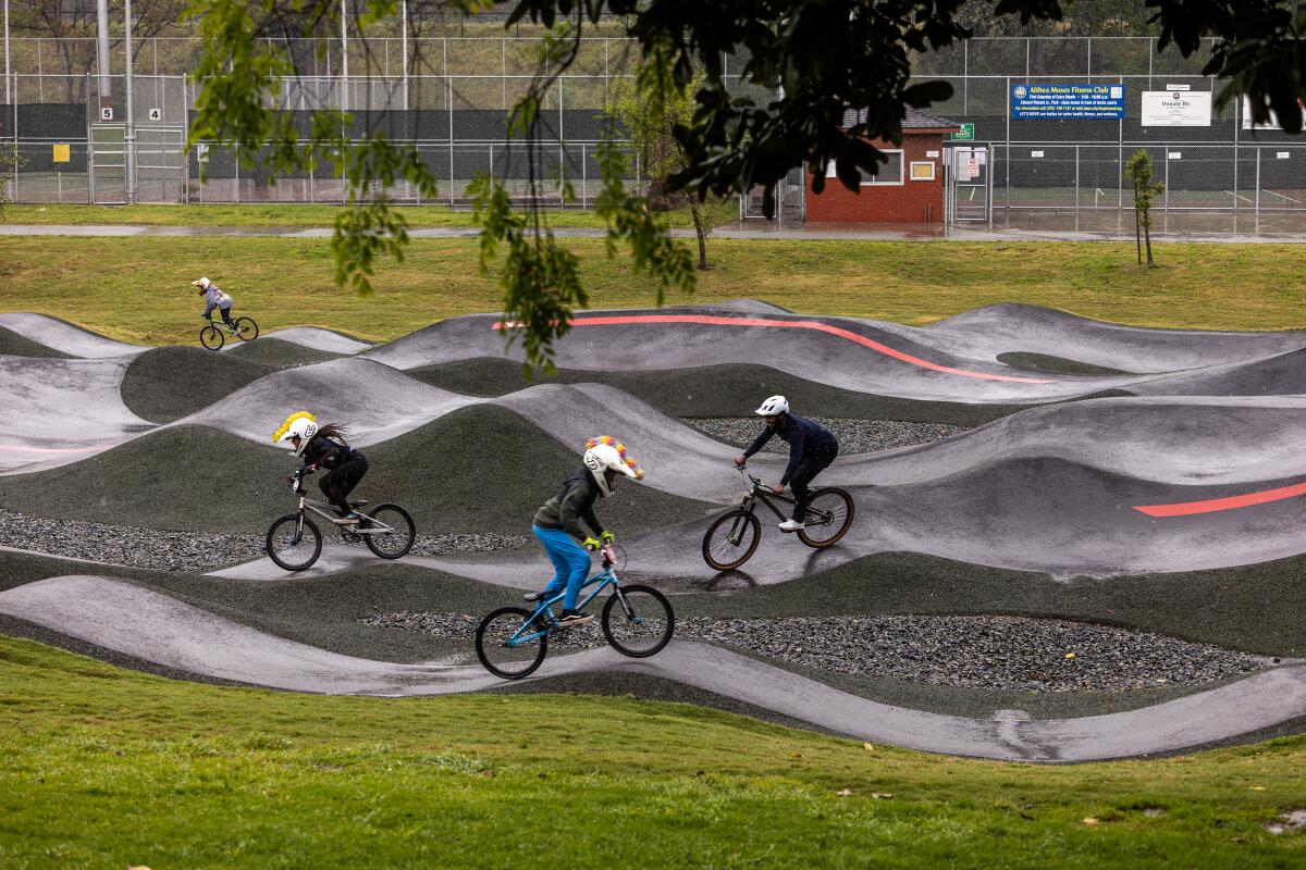 Eliot Jackson, a pro mountain biker, right, rides the Inglewood Pumptrack with pro BMX riders.