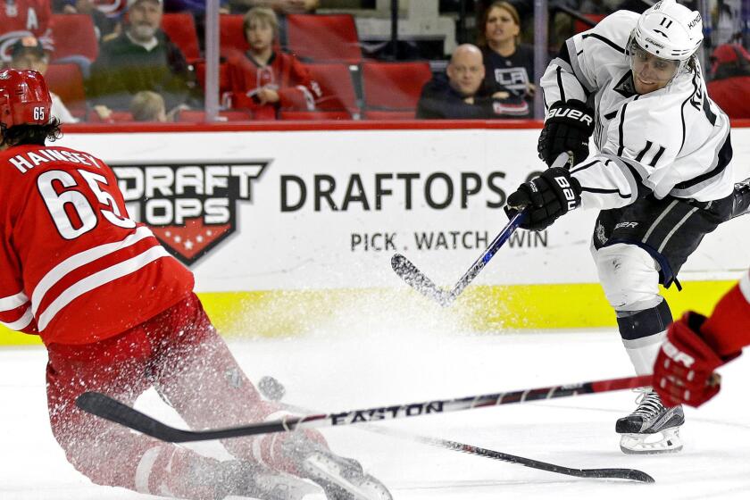 Kings center Anze Kopitar sends a shot past Hurricanes defenseman Ron Hainsey that found the net in the second period Sunday.