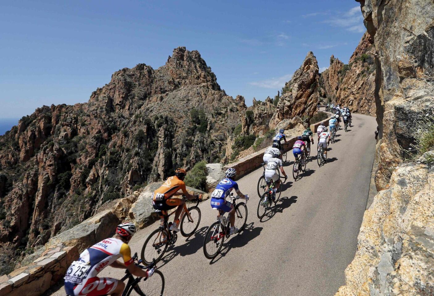 The pack of riders cycles on its way past the calanque de Piana during the 145,5 km third stage of the centenary Tour de France cycling race from Ajaccio to Calvi