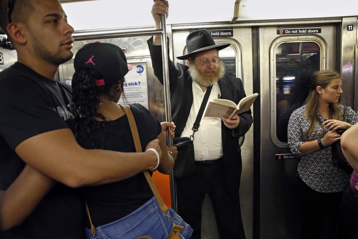 Rabbi Yosef Katzman, center, and others on the New York subway in September 2014.