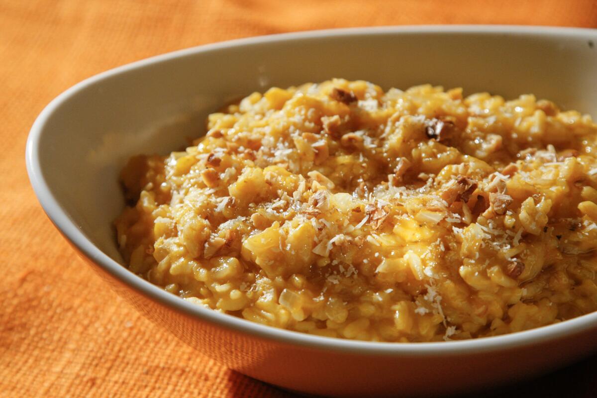 Closeup of a dish of creamy rice sprinkled with Parmesan.