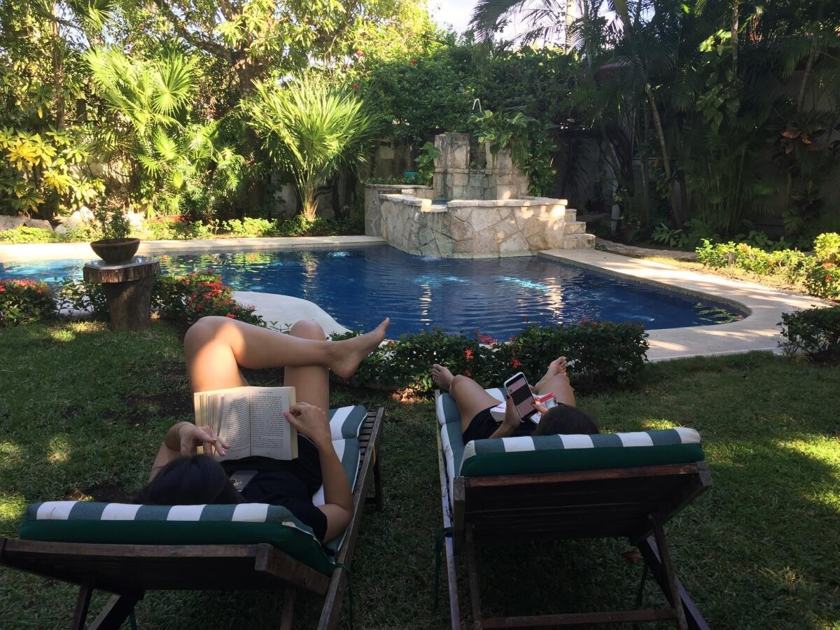En Cozumel, México, personas leen junto a la piscina en el patio de su alojamiento. México es un destino popular para los vacacionistas durante el invierno y la primavera especialmente a aquellos que no están interesados en los hoteles todo incluido por los que es conocido Cancún.