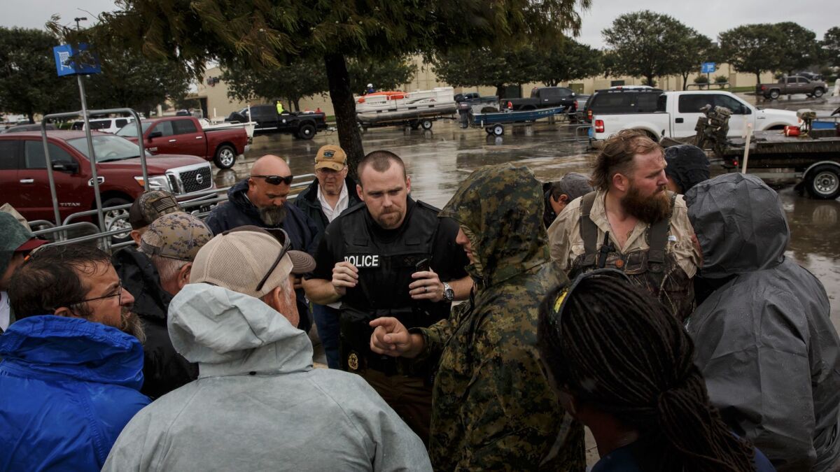 Volunteers from Fort Worth gather around Port Arthur Deputy Police Chief Cory Cole before they head out for rescue operations.
