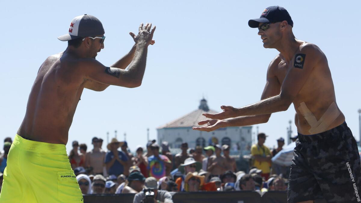Sean Rosenthal, left, Phil Dalhausser slap hands during their victory in the AVP Manhattan Beach Open final on Sunday.